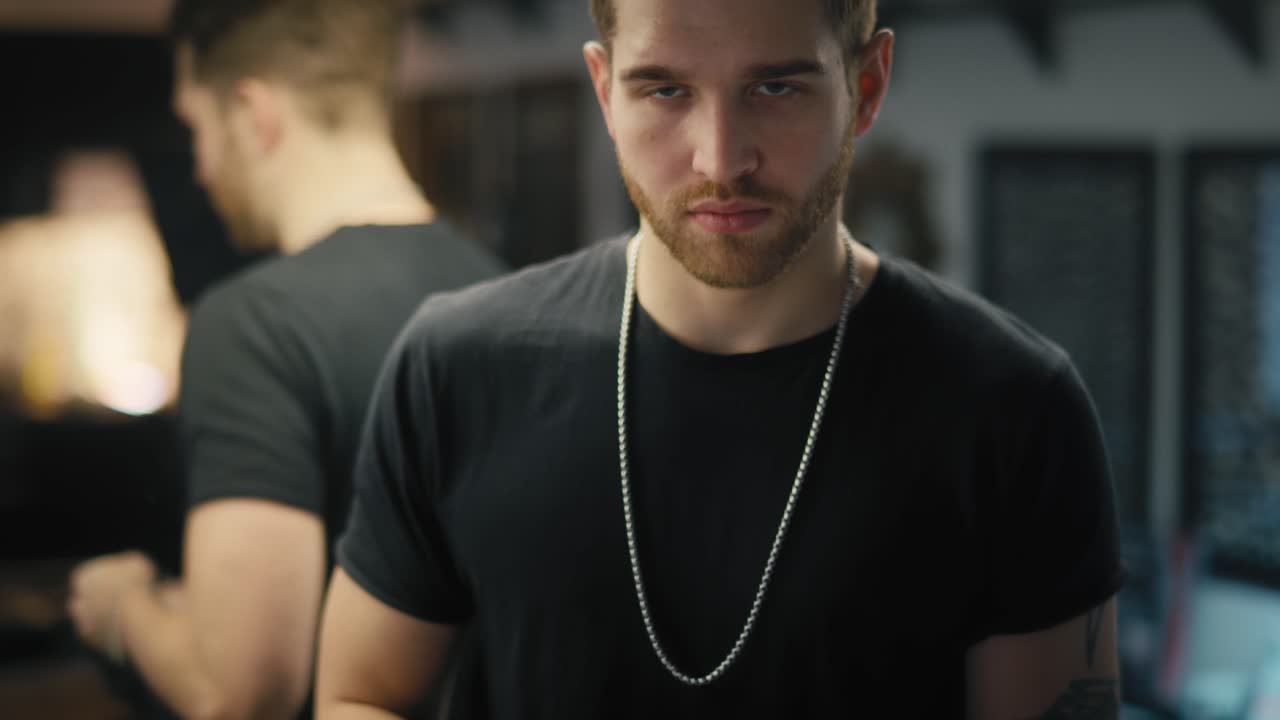 el propietario caucásico de un estudio de tatuajes quitándose los guantes desechables.