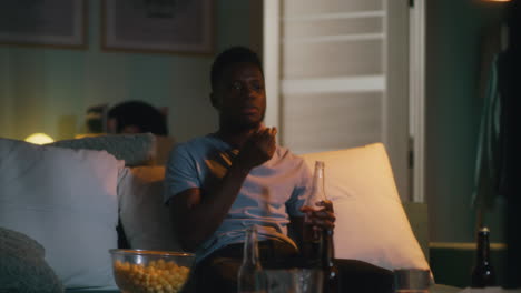 man watching tv and eating popcorn