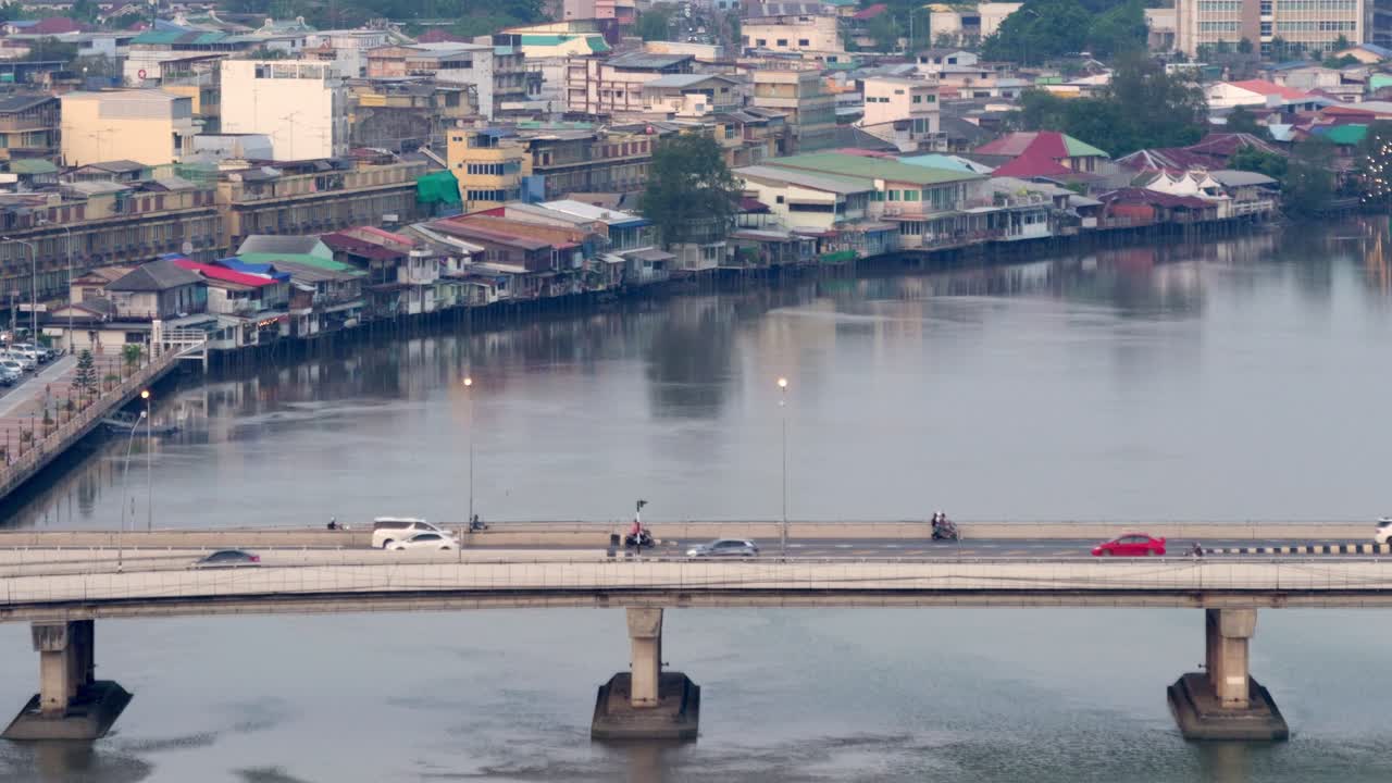 High-angle shot of Bang Pakong River at sunset with houses lining both riverbanks, showing the residential charm of Chachoengsao.