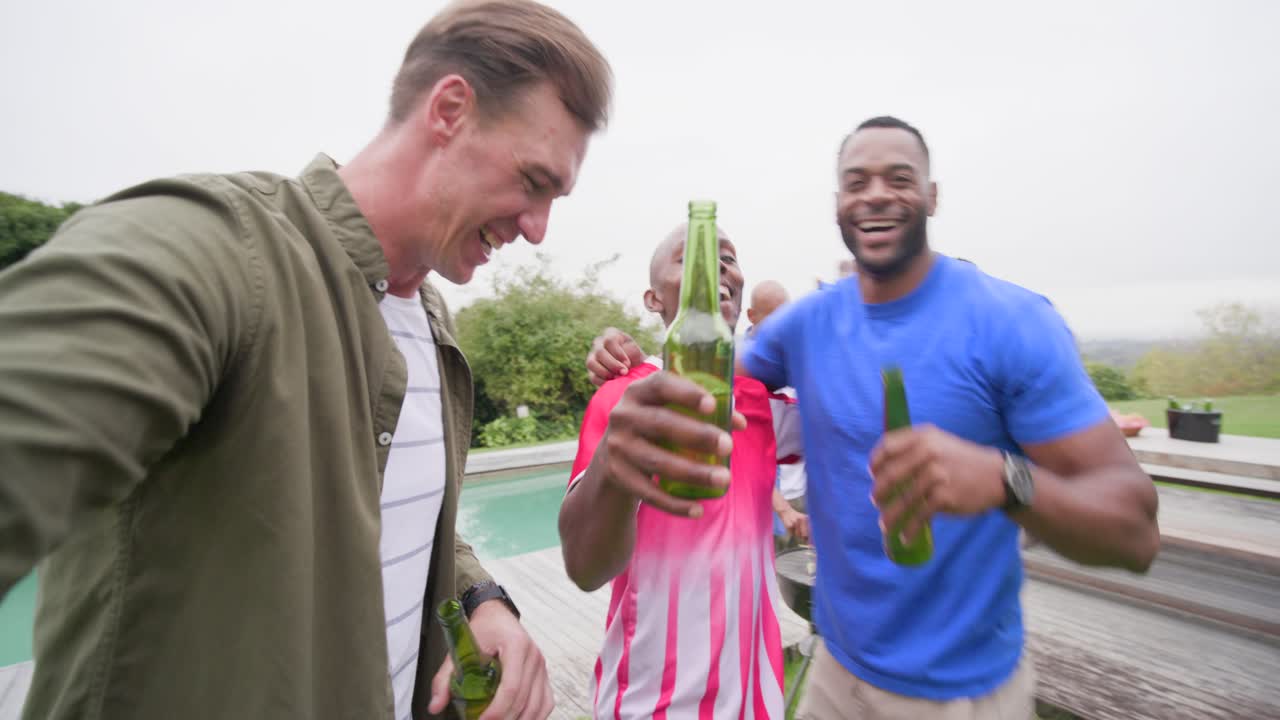 Diverse mannelijke vrienden komen samen terwijl de gastheer een selfie filmt, iemand grilt en burgers omdraait in de tuin, met ruimte voor tekst.