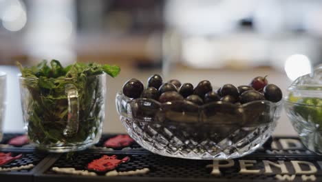 Bar-garnish-grapes,-limes,-and-herbs,-handheld-camera-shot-from-left-to-right