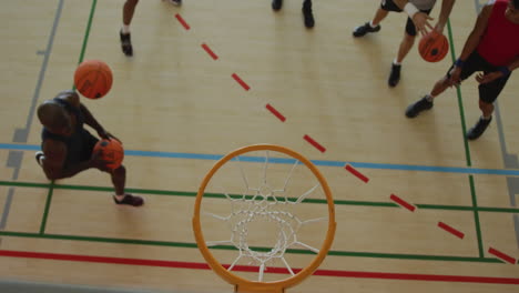 overhead view of african american male basketball player scoring goal against diverse players