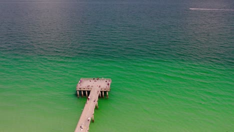 imágenes de drones de un hermoso muelle con aguas verdes y azules del océano