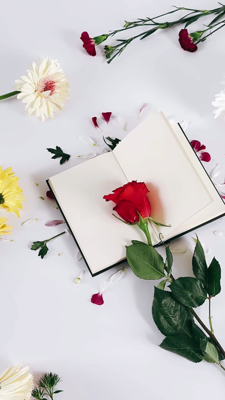 Flowers and a Rose on an Open Book