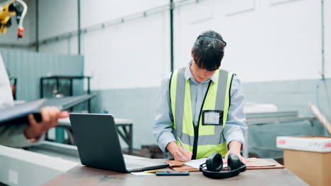 factory worker reviewing documents at workstation