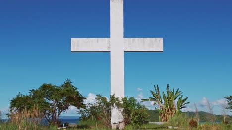 Cruz-Blanca-Gigante-En-El-Antiguo-Cementerio-Católico-En-Claver,-Surigao-Del-Norte,-Filipinas-Efecto-De-Disparo-De-Muñeca-Con-Zoom