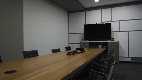 general view of empty conference room with television monitor, table and chairs in office