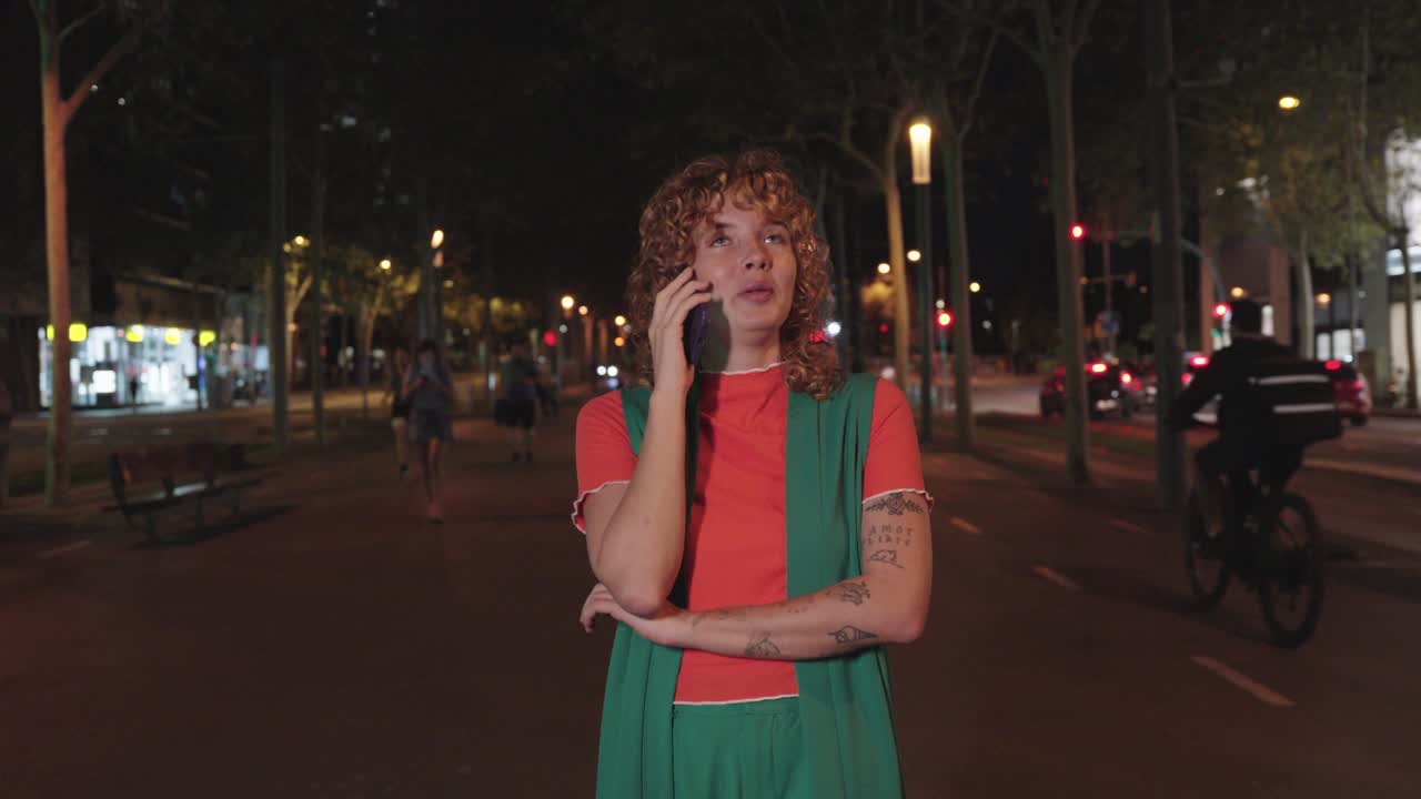 Woman talking on the phone at night on a city street