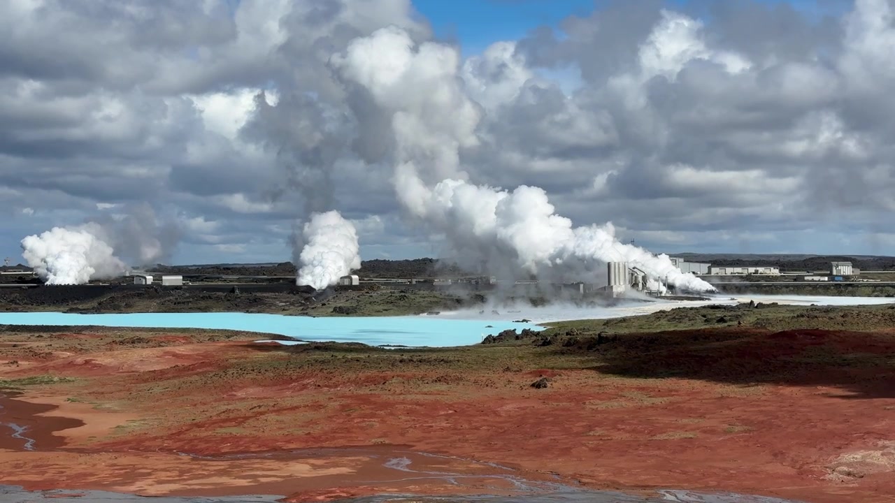 Produksi energi panas bumi di pembangkit listrik Svartsengi di Islandia. Gumpalan uap membumbung ke langit berawan dari fasilitas tersebut