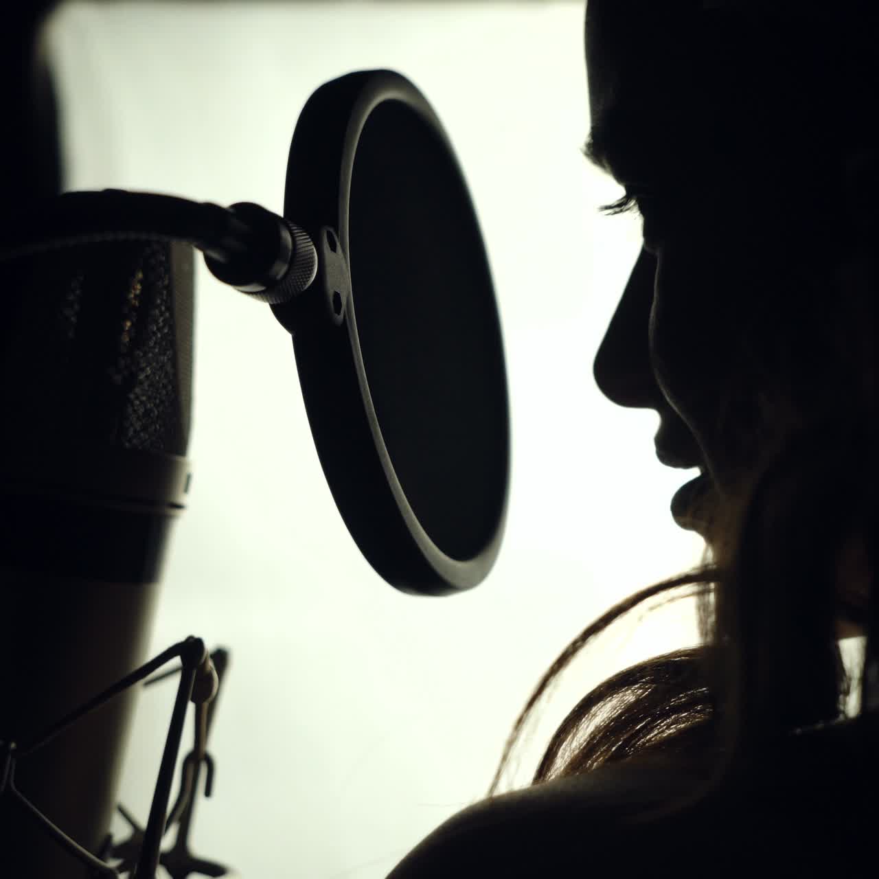 Woman singing in the recording studio. Profile of a woman with a beautiful face and lips. Black and White