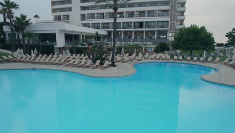 drone clip flying close over a luxurious swimming pool in a hotel resort in mallorca, spain