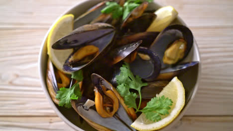 fresh mussels with herbs in a bowl with lemon