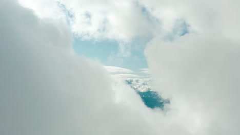 aerial view of majestic mountains and lake peeking through clouds