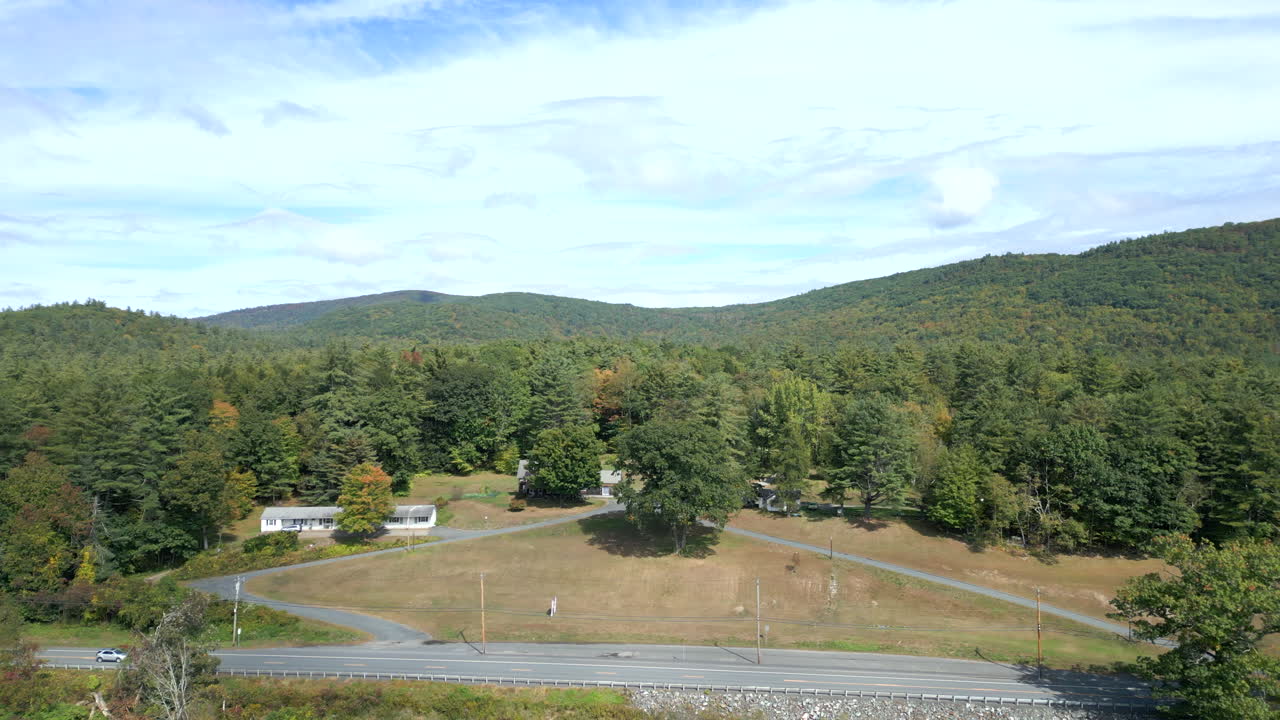 Aerial ascend establishes views of homes alongside Mohawk Trail by Deerfield River in Western Massachusetts New England USA