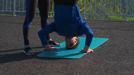 hombre haciendo un headstand al aire libre
