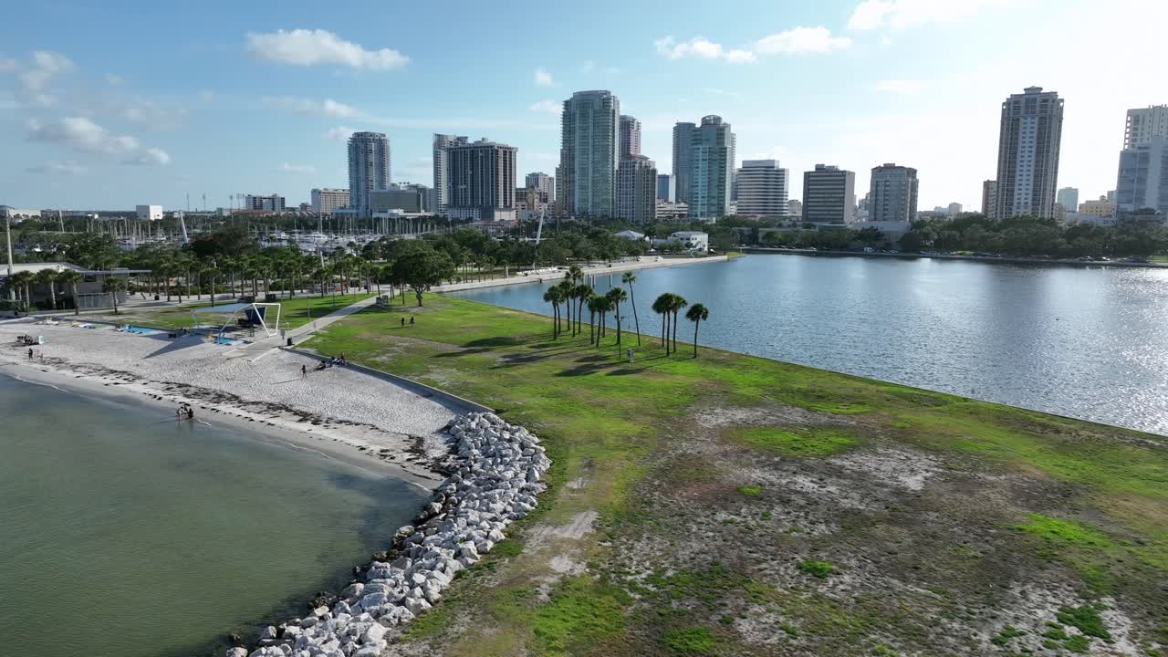 Aerial view of St. Petersburg, Florida skyline with a serene island in foreground. cityscape with modern buildings against blue sky, surrounded by tranquil waters and lush greenery. Wide shot. Fl,usa