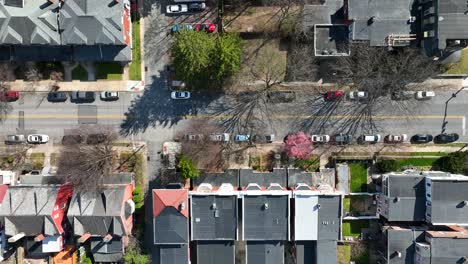 Toma-Aérea-De-Arriba-Hacia-Abajo-De-Los-Coches-De-Estacionamiento-En-La-Franja-Lateral-De-La-Carretera-En-El-Barrio-De-La-Ciudad-Americana-Durante-El-Día-Soleado-De-Verano,-Ee.uu.