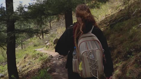 woman walking in a forest trail with a backpack  - parvati valley - himachal pradesh - himalayas, india