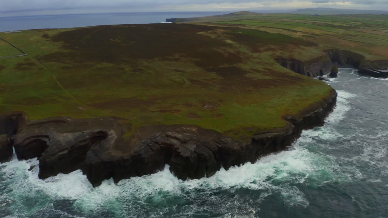 una amplia panorámica aérea captura los dramáticos acantilados de la cabeza del bucle desde kilbaha al sur hasta el faro.