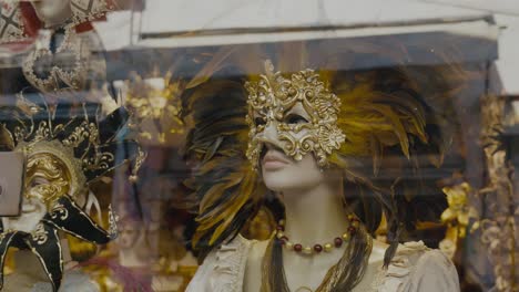 Golden-feathered-mask-on-mannequin-in-Venice,-Italy