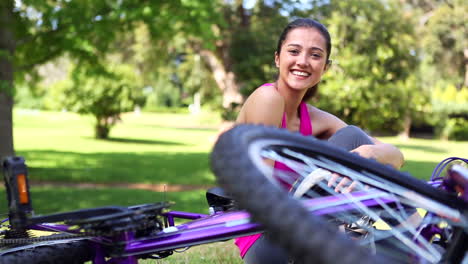 chica en forma quitándose el casco de bicicleta sonriendo a la cámara