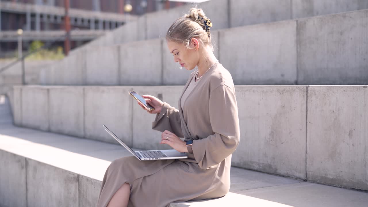 mujer trabajando al aire libre en portátil y teléfono