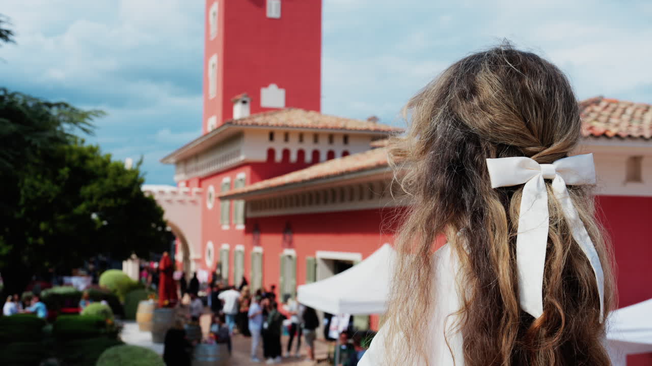 Woman with long hair, dressed in white, posing at the Cremat Castle Winery