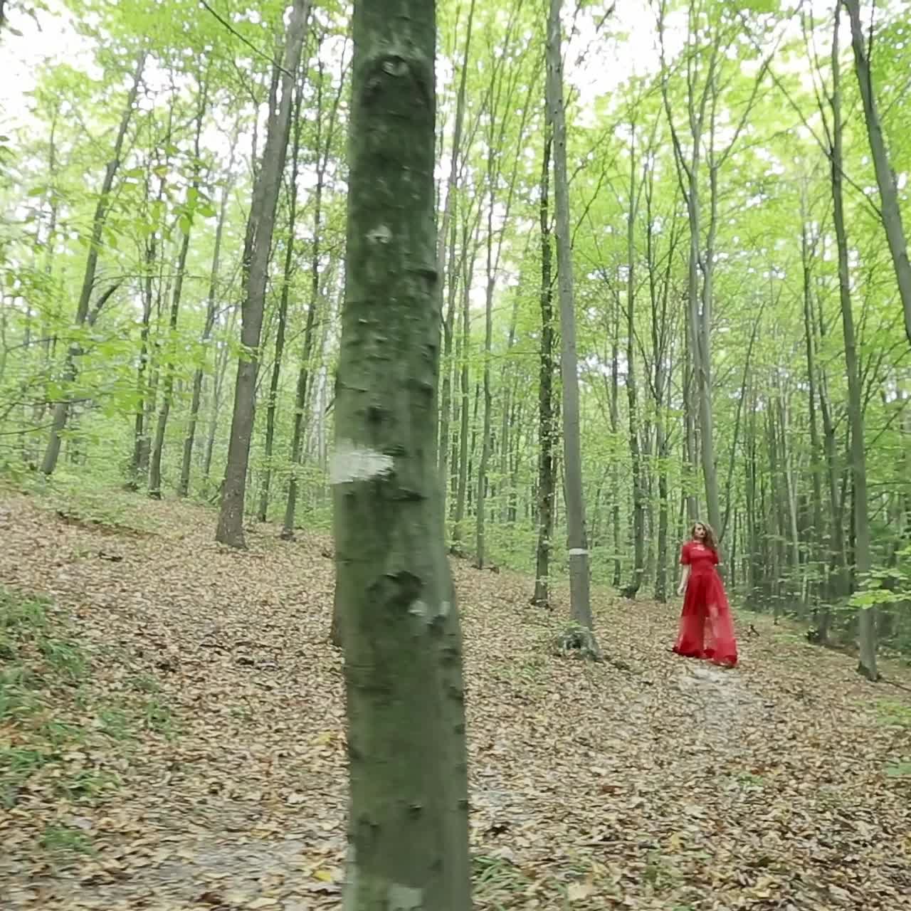una mujer bonita caminando por el bosque.