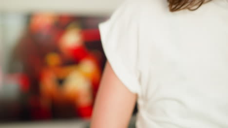 woman turns tv channel jogging at home closeup. training lady watches television show running on treadmill indoors. active workout with entertainment