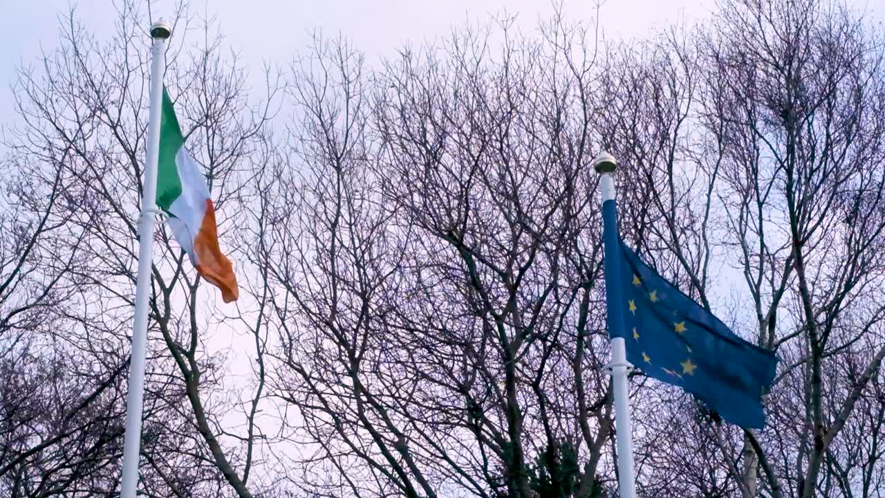 Primo piano delle bandiere dell'Irlanda e dell'UE che sventolano una accanto all'altra