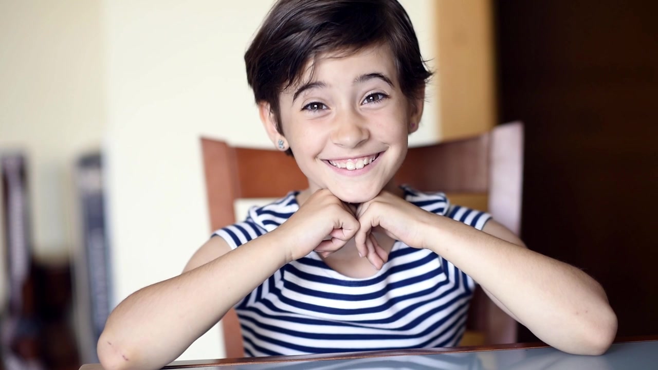 Niña graciosa de ocho años haciendo diferentes expresiones a la cámara en interiores.