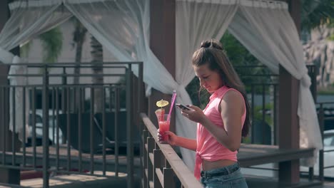 chica con el cabello suelto que fluye mira la pantalla del teléfono en el hotel