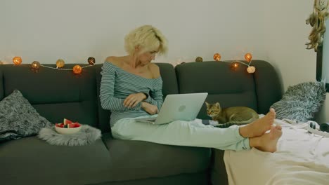 woman working on laptop at home with cat