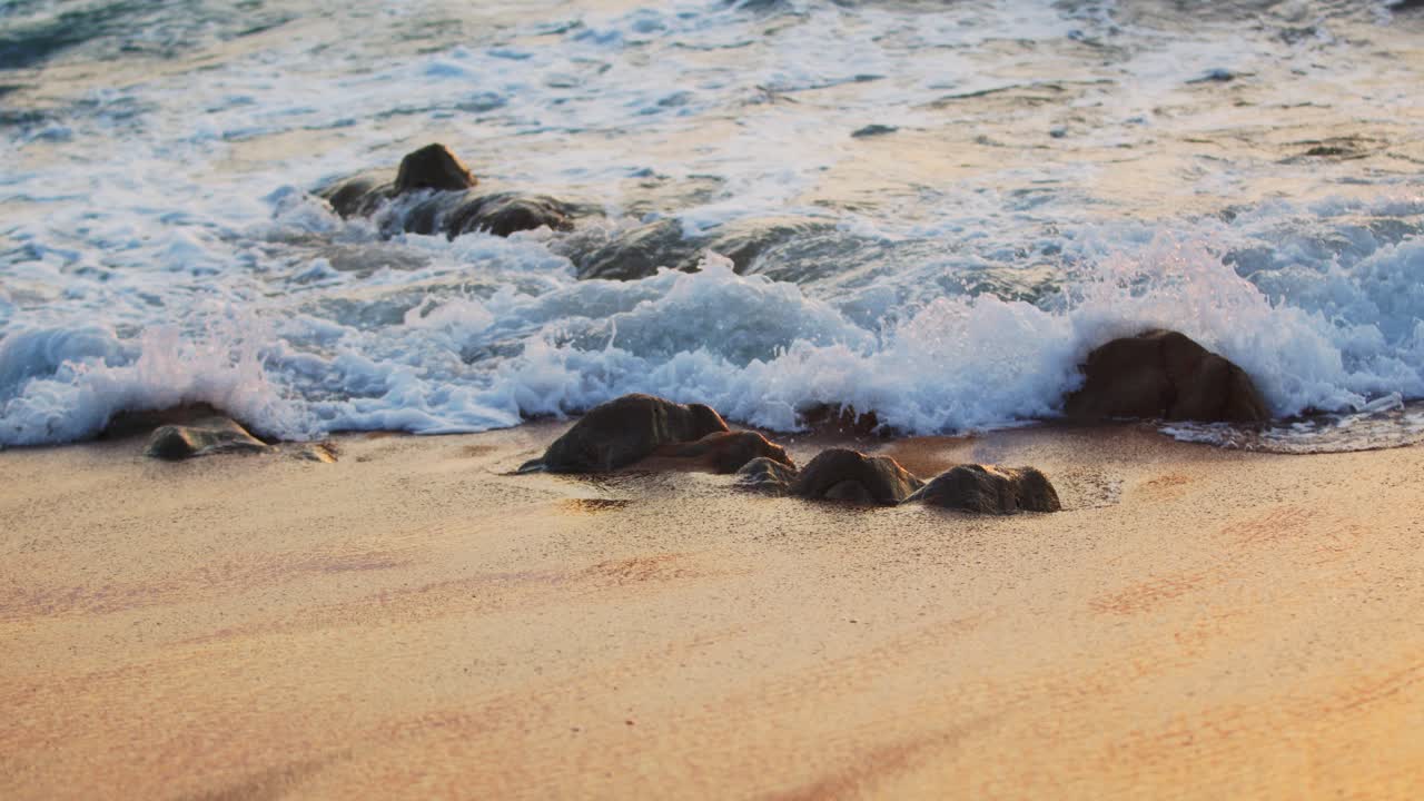 Amazing sunset over the tropical beach Durban, Kwazulu-Natal, Waves crashing on little rocks on the shore at dawn, Morning at sea, sunrise on the sea beach, orange sunlight.