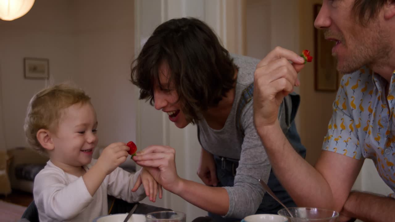 familia caucásica comiendo fresas en casa