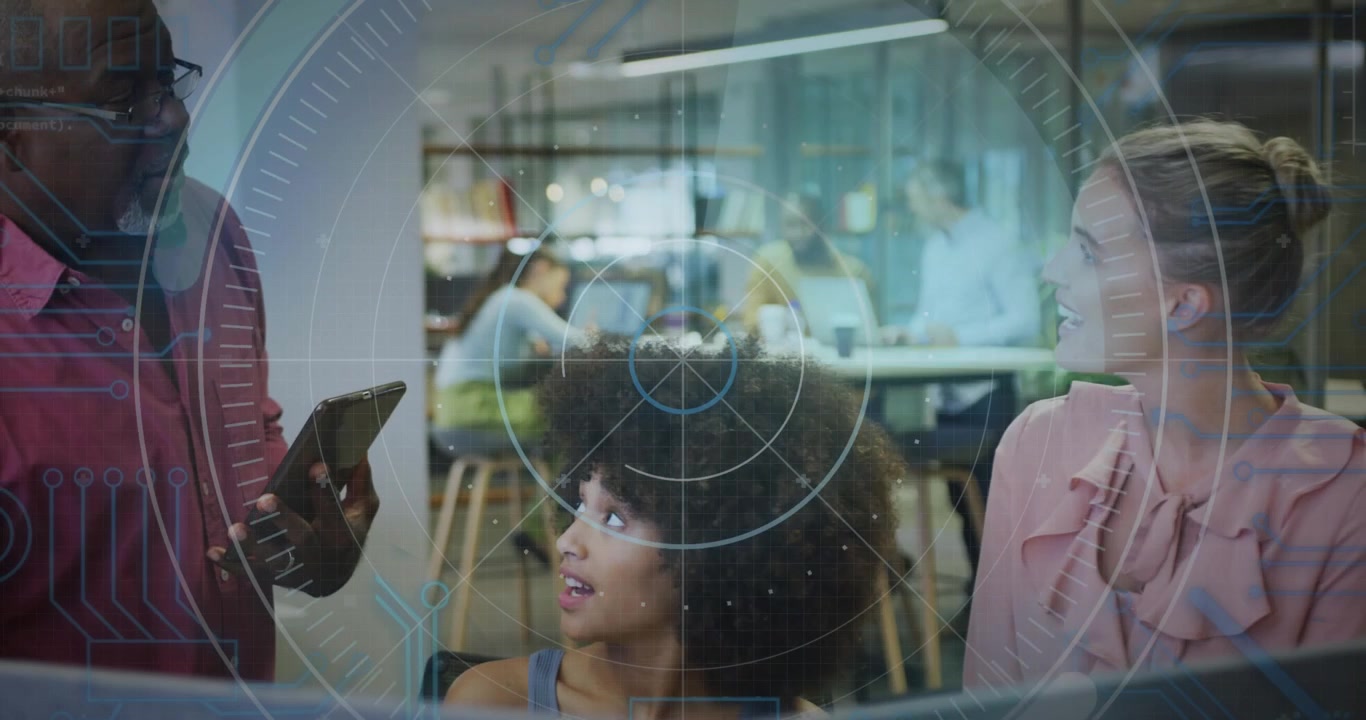 Two women working at office monitor, man approaching holding tablet showing update, HUD hovering