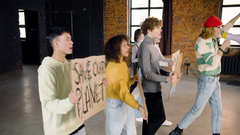 side view of  young environmental activists with placards and megaphone walking and protesting against climate change inaction