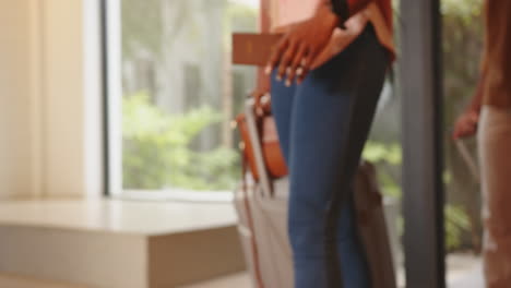 holding passport and suitcase, woman preparing for travel at home