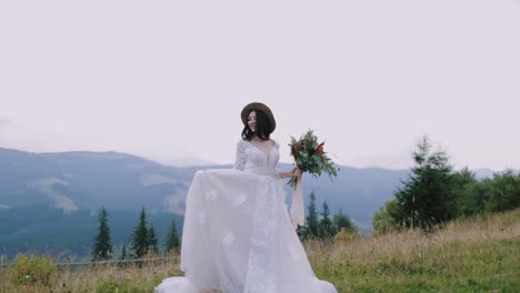 Bride on mountain landscape. Romantic beautiful bride in white dress posing on mountain