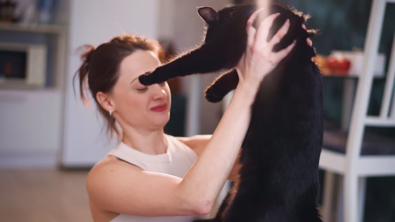 Joyful Pet Bonding, Woman Cuddling Black Cat Happily, Woman Embracing Black Feline With Joy Inside Home Setting, Happy Woman Holding And Cuddling Black Cat Within Cozy Living Room Environment