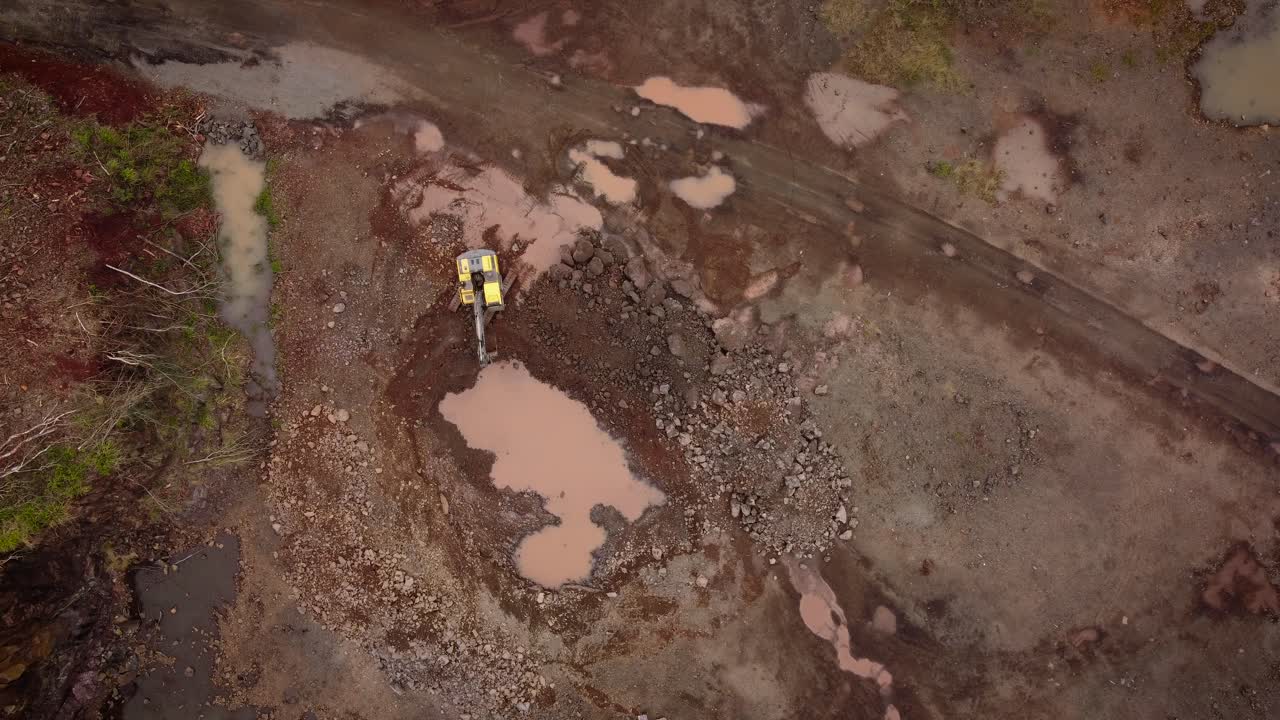 excavadora trabajando en cantera de piedra, vista aérea de arriba hacia abajo