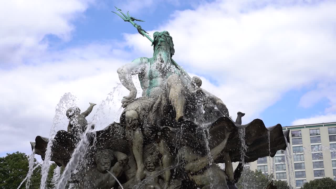 베를린 에 있는 네프 ⁇  분수 의 전면 사진 과 거품 을  ⁇ 는 물 과 구름 을 배경 으로 한 파란 하늘