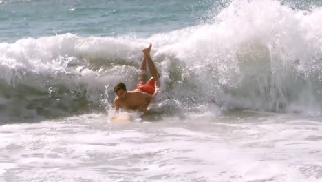 surfer taking a wave and falling