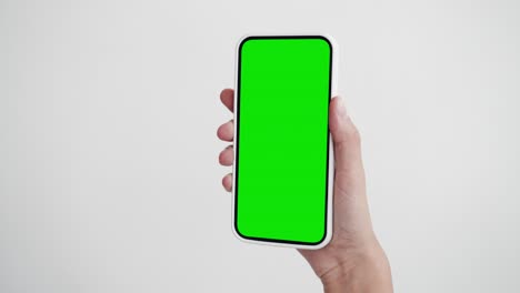 young person use smartphone with green screen chroma key close-up. girl hold in hand clicking cell phone mock-up pov. concept watch show internet social media, calls, read news, app, iot, e-shopping