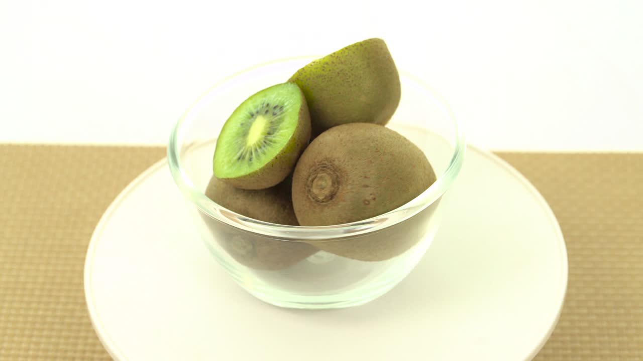 Kiwi freschi, maturi e verdi in una ciotola in rotazione