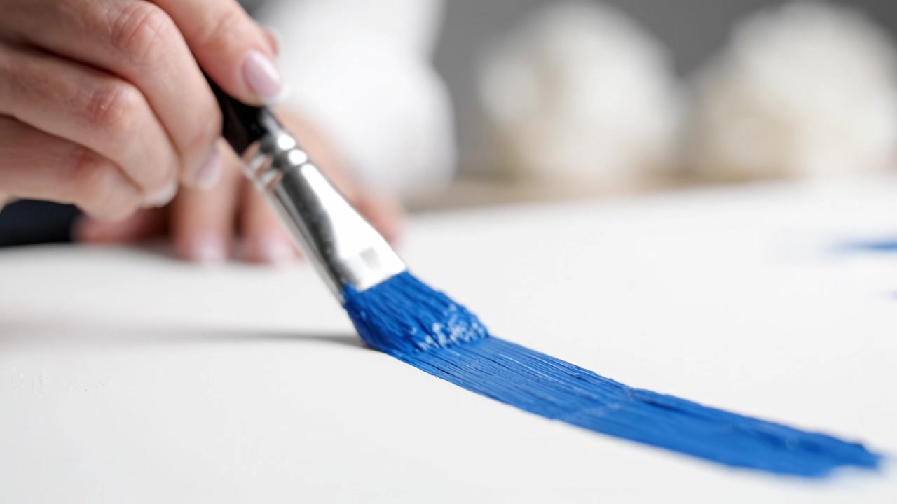 Espressione artistica attraverso le pennellate: catturare il processo di applicazione della pittura blu su tela in un contesto artistico coinvolgente e creativo.