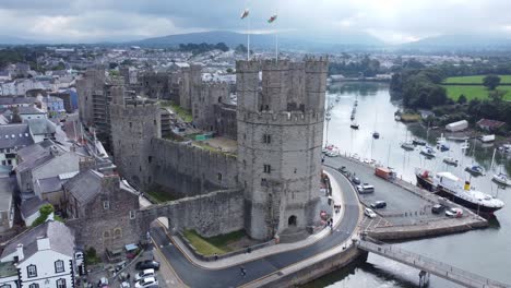 ancient caernarfon castle welsh harbour town aerial view medieval waterfront landmark fast orbit left