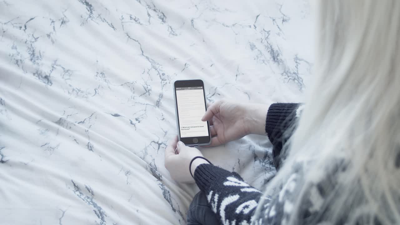 mujer usando teléfono inteligente en la cama