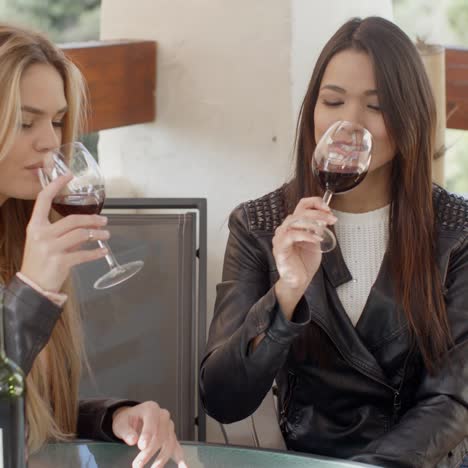 Zwei-Attraktive-Mädchen-Sitzen-Auf-Dem-Balkon-Mit-Wein