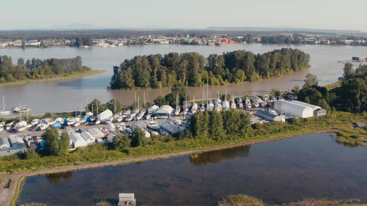 yvr 공항에서 불과 몇 킬로미터 떨어진 캐나다 bc 주 리치먼드의 더운 여름날 프레이저 강 옆에 있는 보트 요트 크루저 저장 마당 옆에 있는 크랜베리 농장 위로 공중 비행